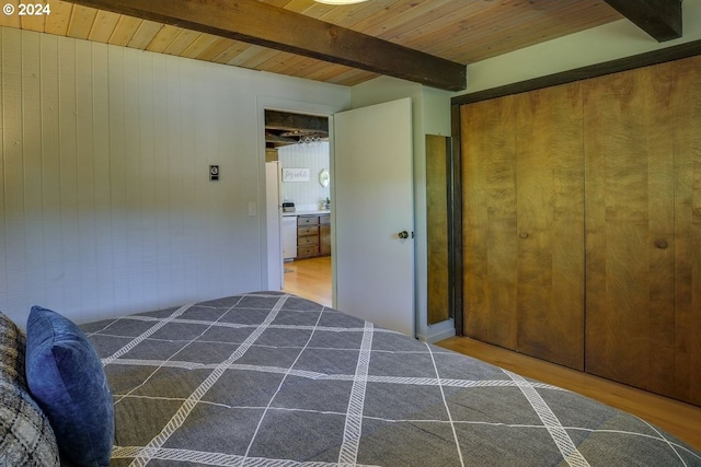 bedroom featuring beam ceiling, dark hardwood / wood-style floors, a closet, and wooden ceiling