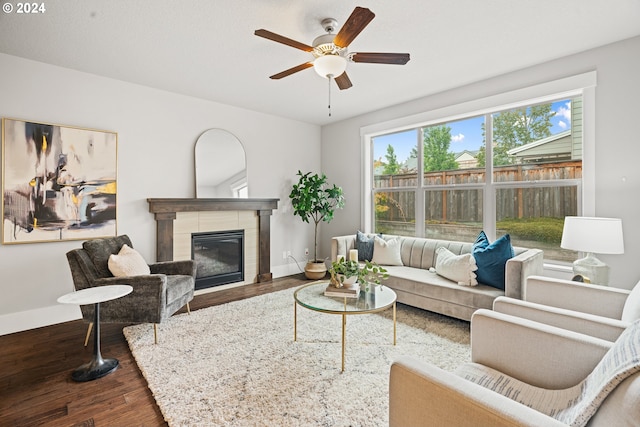 living room featuring ceiling fan, hardwood / wood-style flooring, and a fireplace