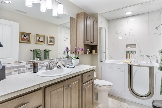 bathroom featuring vanity, toilet, and tasteful backsplash