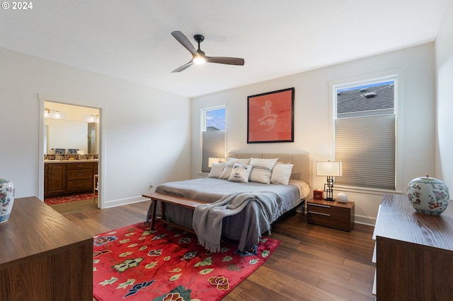 bedroom featuring ensuite bath, dark wood-type flooring, and ceiling fan