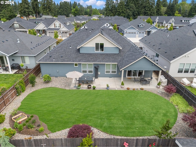 rear view of house featuring a yard and a patio area