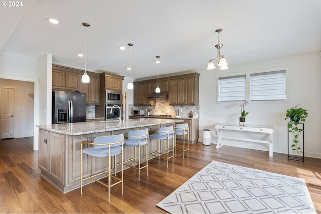 kitchen featuring a spacious island, stainless steel appliances, pendant lighting, and dark hardwood / wood-style flooring