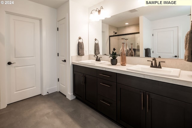 bathroom featuring a shower with door and vanity