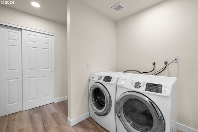 laundry room featuring separate washer and dryer and light wood-type flooring