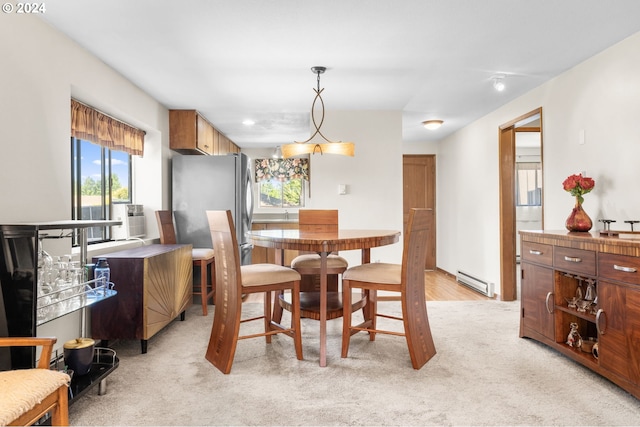 carpeted dining room with a baseboard heating unit