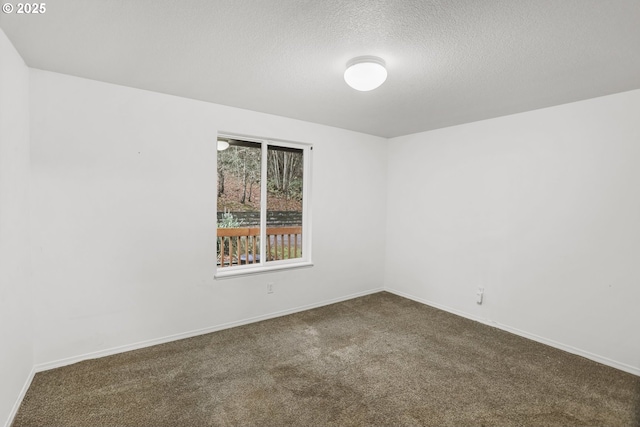 carpeted empty room featuring a textured ceiling