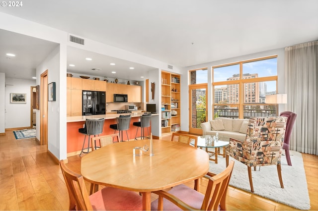 dining room with light hardwood / wood-style floors and built in shelves