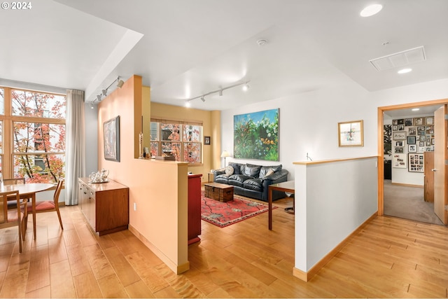 corridor featuring light hardwood / wood-style floors and track lighting