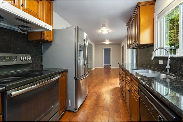 kitchen with hardwood / wood-style floors, appliances with stainless steel finishes, backsplash, and sink