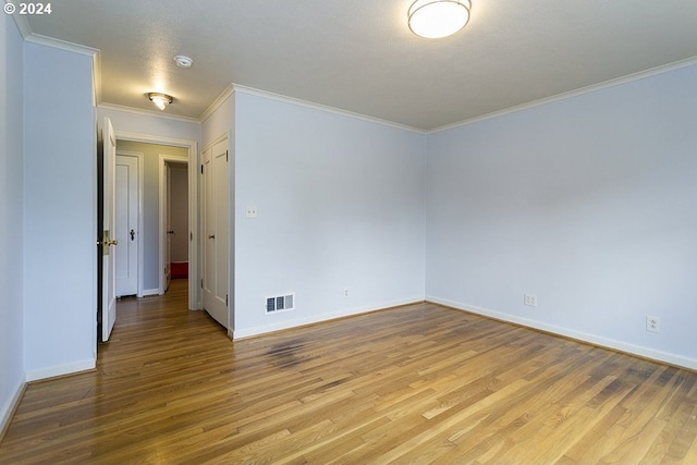 spare room featuring ornamental molding and light hardwood / wood-style flooring