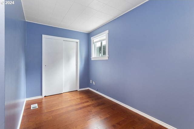 unfurnished bedroom with wood-type flooring and a closet