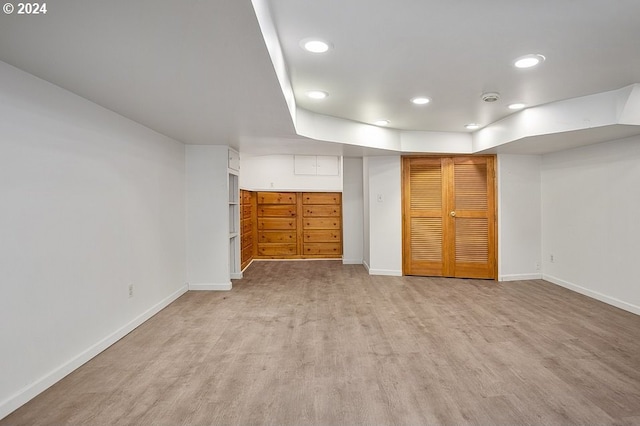 basement with light hardwood / wood-style flooring