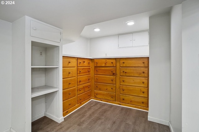 walk in closet with dark hardwood / wood-style floors