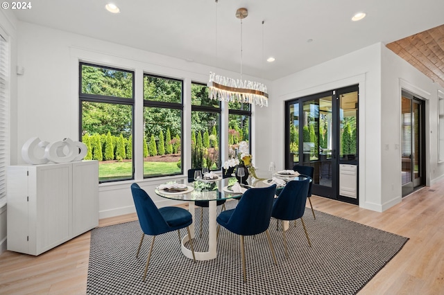 dining area with an inviting chandelier and light hardwood / wood-style flooring