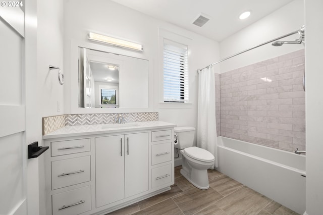 full bathroom featuring shower / bath combo, vanity, tasteful backsplash, and toilet