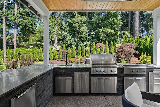 view of patio featuring an outdoor kitchen, area for grilling, and sink