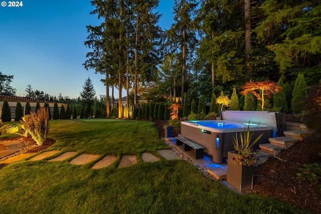 yard at dusk with a hot tub