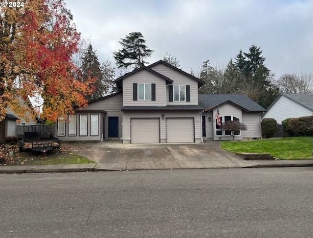 front facade featuring a garage and a front lawn