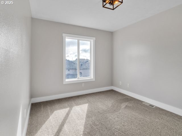724 Kayla Way, Monmouth, OR 97361 - carpeted empty room with baseboards and visible vents