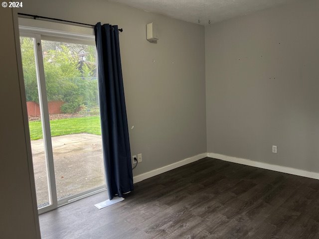 empty room featuring dark hardwood / wood-style floors and a textured ceiling