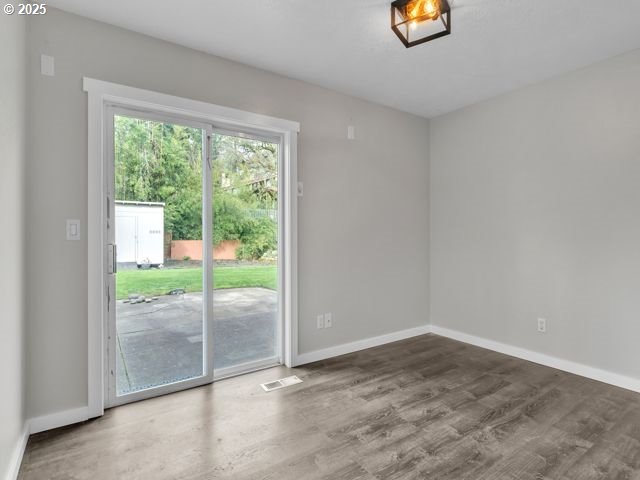 724 Kayla Way, Monmouth, OR 97361 - unfurnished room featuring baseboards, visible vents, and wood finished floors
