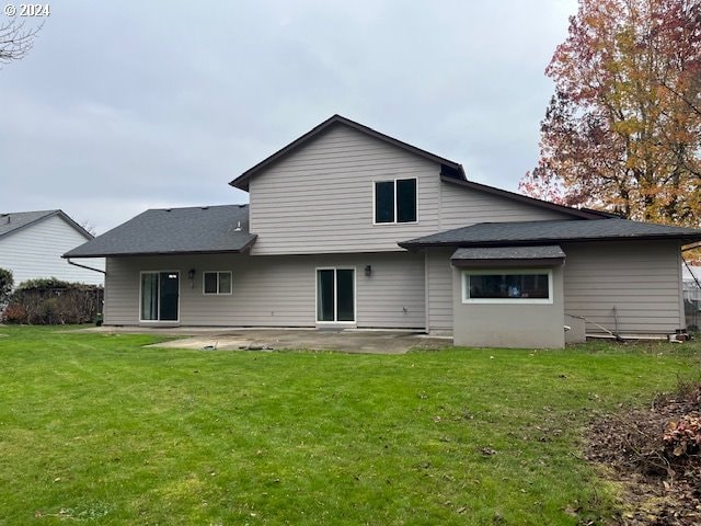 rear view of house featuring a patio area and a yard