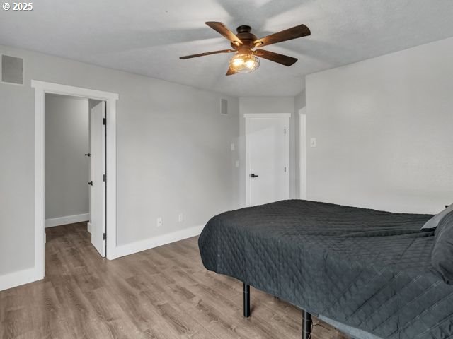 724 Kayla Way, Monmouth, OR 97361 - bedroom featuring a ceiling fan, wood finished floors, baseboards, and visible vents