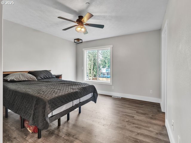 724 Kayla Way, Monmouth, OR 97361 - bedroom with a textured ceiling, visible vents, baseboards, wood finished floors, and a ceiling fan