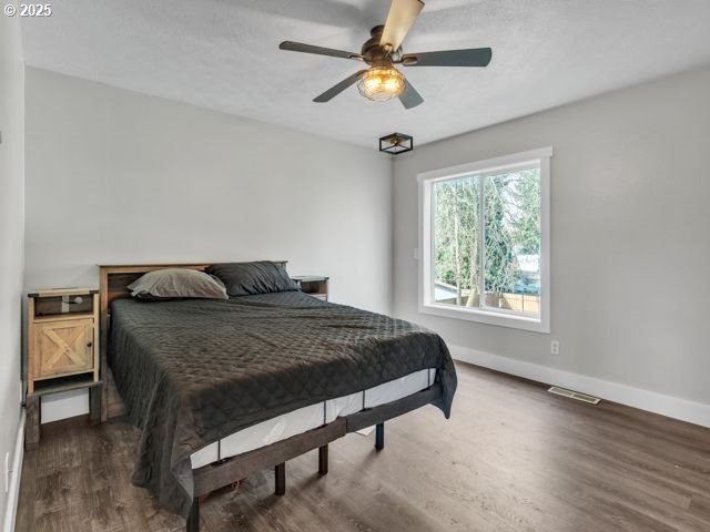 724 Kayla Way, Monmouth, OR 97361 - bedroom featuring baseboards, visible vents, wood finished floors, and a ceiling fan