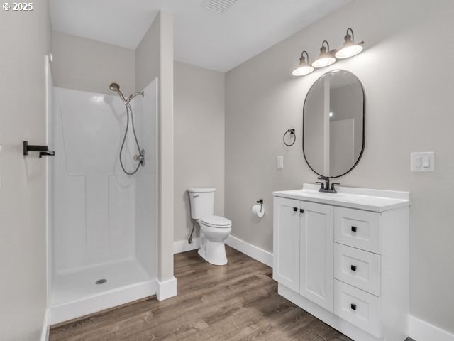 724 Kayla Way, Monmouth, OR 97361 - full bathroom with vanity, toilet, walk in shower, visible vents, and wood finished floors