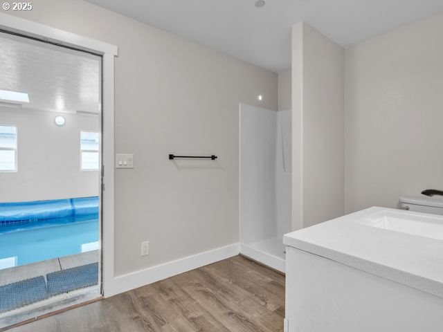 724 Kayla Way, Monmouth, OR 97361 - full bath featuring baseboards, wood finished floors, vanity, and walk in shower