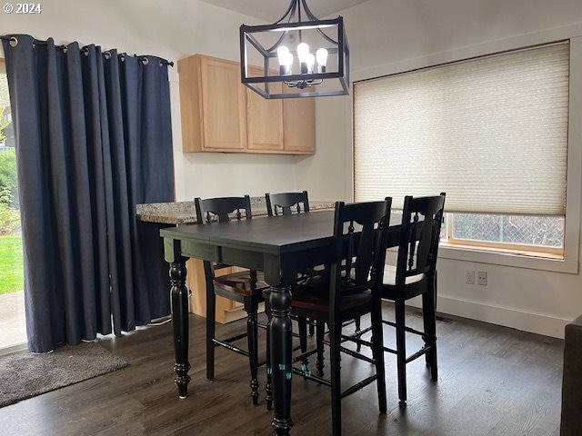 dining room with dark hardwood / wood-style floors and a notable chandelier