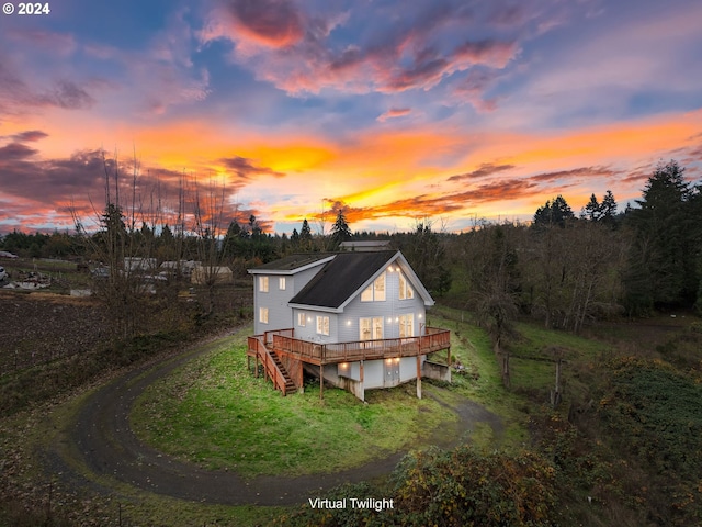 rear view of property featuring driveway, stairway, and a deck