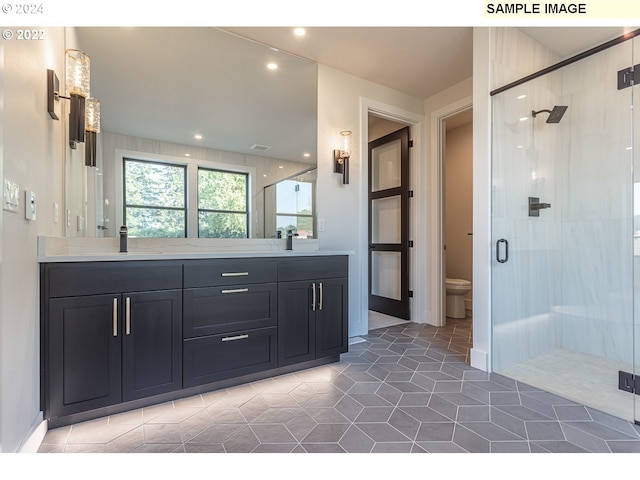 bathroom featuring vanity, tile patterned floors, toilet, and walk in shower