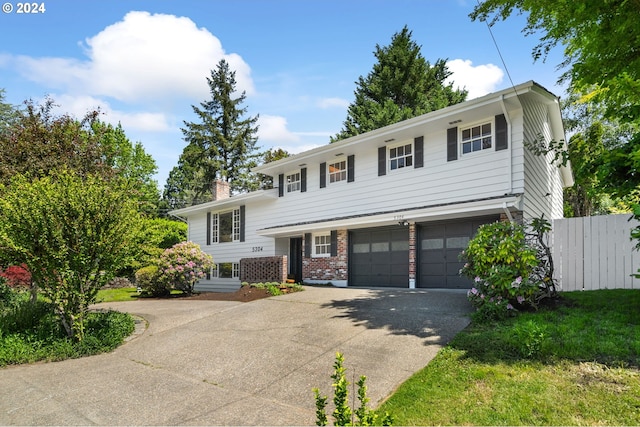 view of front of property with an attached garage, brick siding, fence, driveway, and a chimney