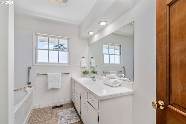 full bath with a bathtub, visible vents, vanity, and baseboards