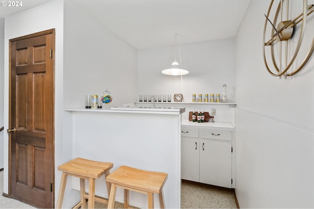 kitchen featuring a sink, white cabinetry, light speckled floor, and light countertops