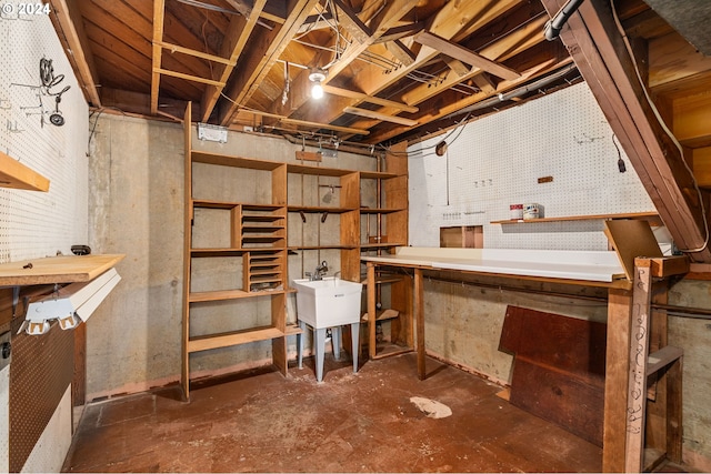 unfinished basement featuring a sink and a workshop area