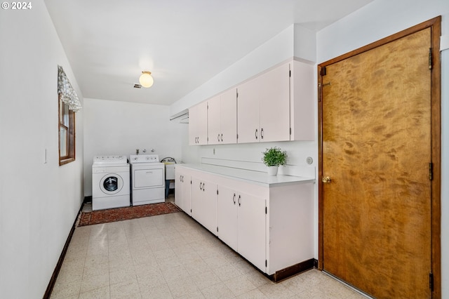 clothes washing area with light floors, independent washer and dryer, cabinet space, and baseboards