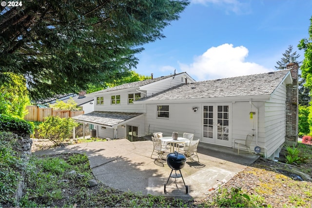 rear view of property featuring french doors, a chimney, a patio area, and fence