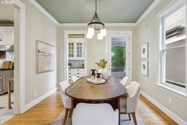 dining room featuring crown molding, light hardwood / wood-style flooring, and an inviting chandelier