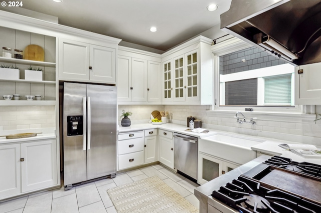 kitchen with sink, light tile patterned floors, backsplash, white cabinets, and appliances with stainless steel finishes