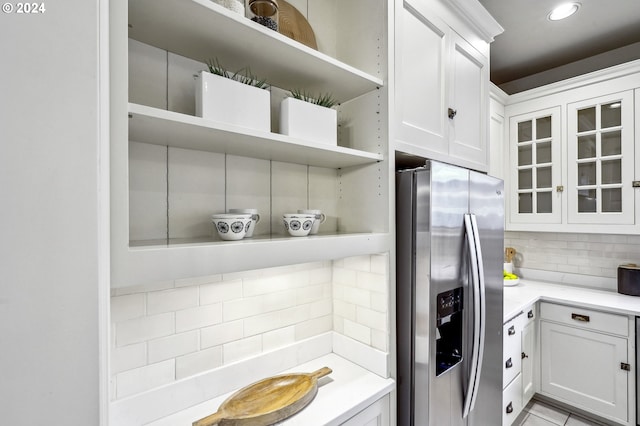 kitchen featuring decorative backsplash, white cabinetry, and stainless steel refrigerator with ice dispenser