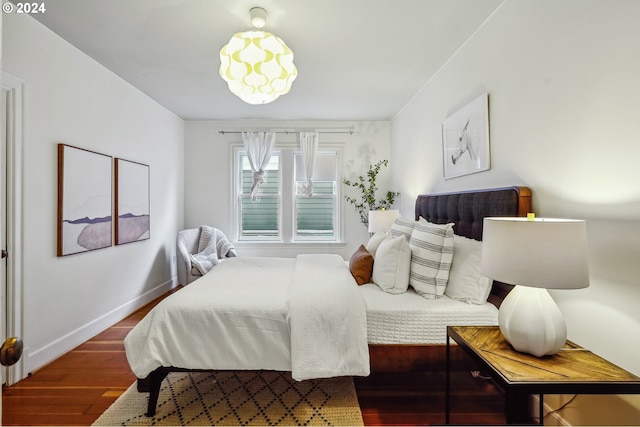 bedroom with dark hardwood / wood-style floors