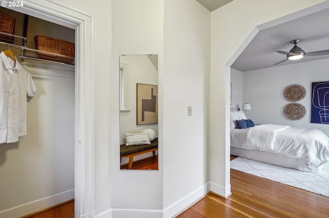 bedroom with ceiling fan, wood-type flooring, and a closet