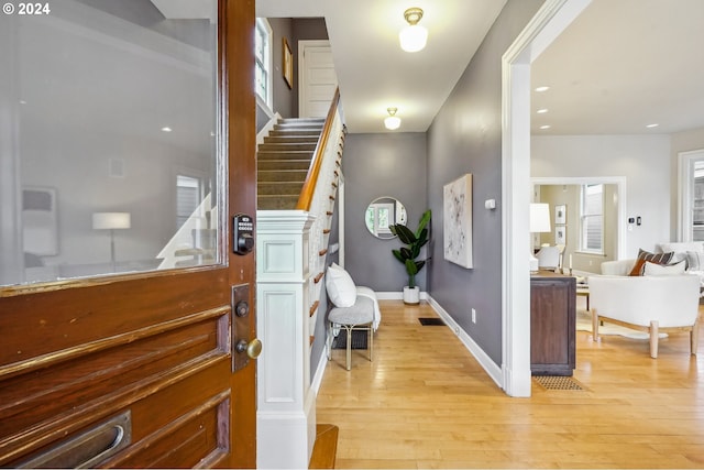 foyer entrance with a wealth of natural light and light hardwood / wood-style flooring