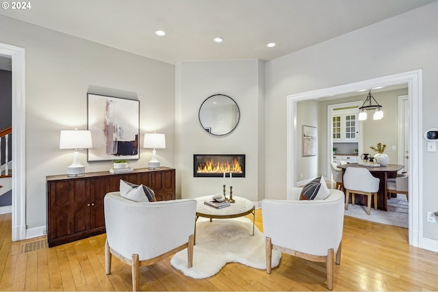 sitting room featuring a notable chandelier and light hardwood / wood-style floors