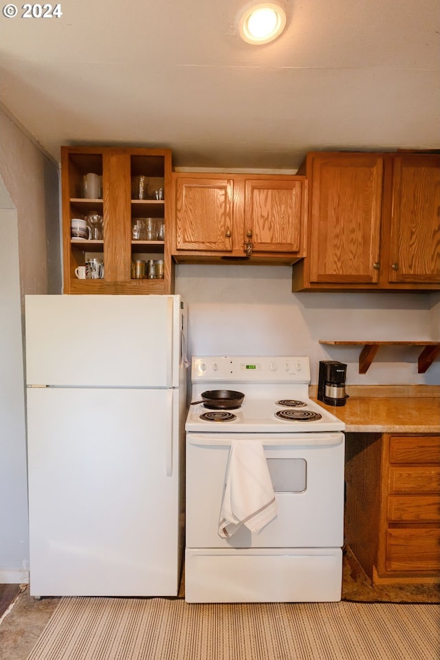 kitchen with brown cabinets, white appliances, light countertops, and open shelves