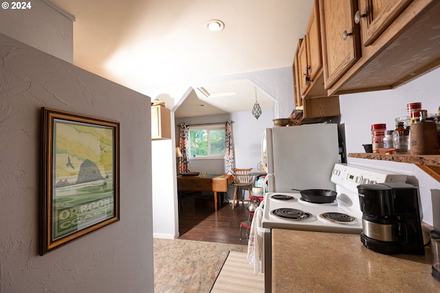 kitchen with white appliances, light wood finished floors, brown cabinetry, a textured wall, and pendant lighting