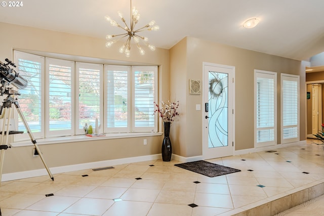 tiled foyer featuring an inviting chandelier and lofted ceiling